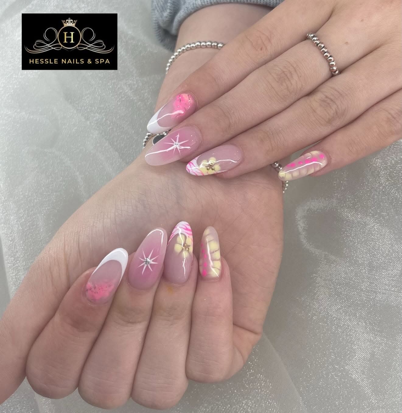 Nude nail art with sparkle stars and a hand-painted flower accent